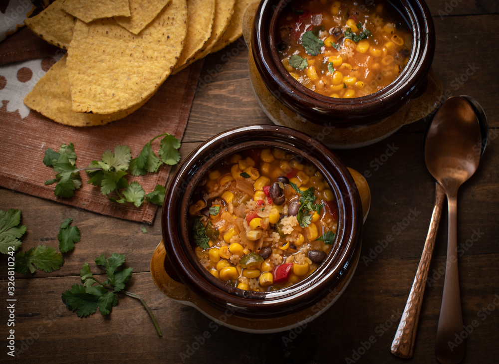 Vegan Mexican soup made with corn, pasta,black beans, green chiles. Served in clay pots Vegan Mexican soup made with corn, pasta,black beans, green chiles. Served in clay pots