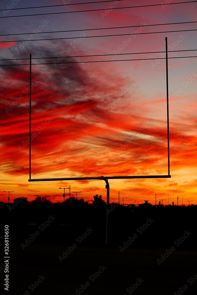 A silhouette of a football goal post at sunset in Arizona.