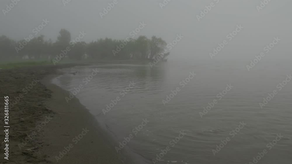 Foggy morning on the lake, low clouds. Scenic view of the river Foggy morning on the lake, low clouds. Scenic view of the river