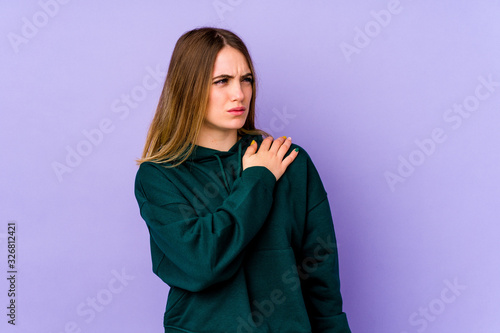 Young caucasian woman isolated on purple background having a shoulder pain. © Asier