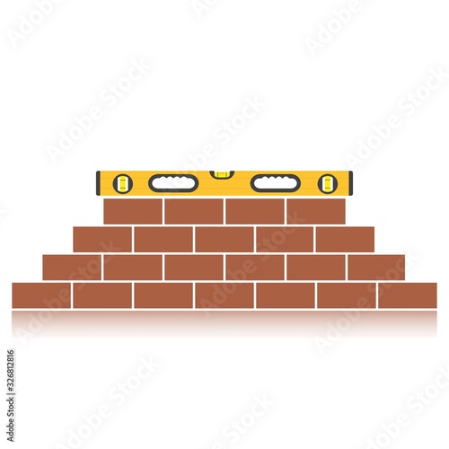 Bubble level laying on top of a brick wall. Construction leveling tool. Building a wall