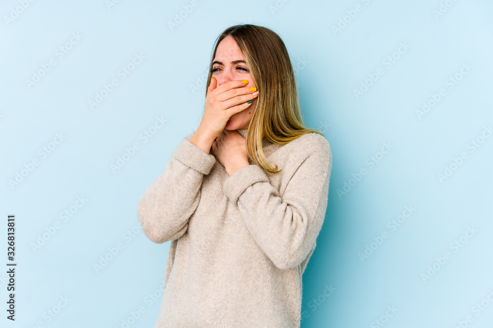 Young caucasian woman isolated on blue background suffers pain in throat due a virus or infection. Young caucasian woman isolated on blue background suffers pain in throat due a virus or infection.