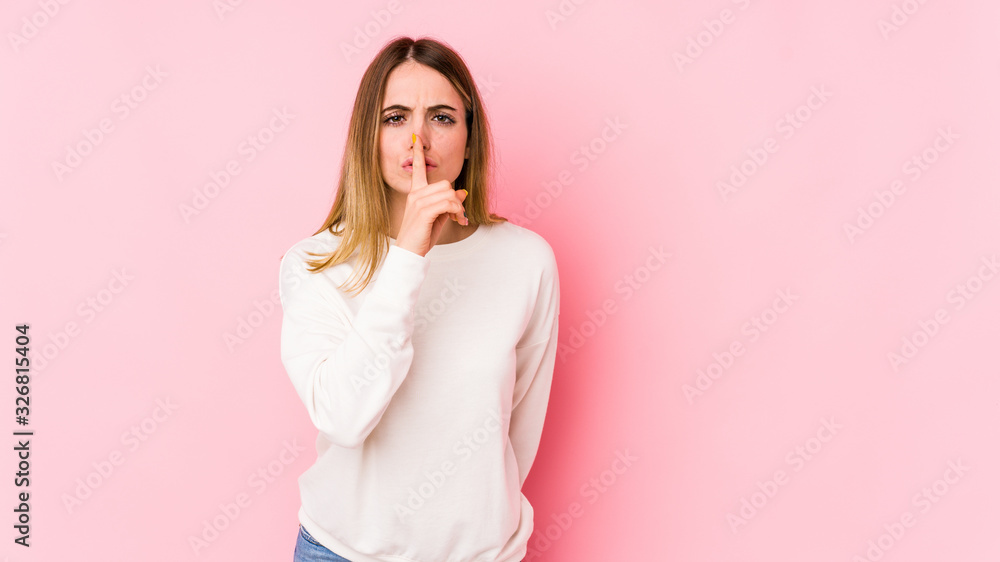 Young caucasian woman isolated on pink background keeping a secret or asking for silence. Young caucasian woman isolated on pink background keeping a secret or asking for silence.
