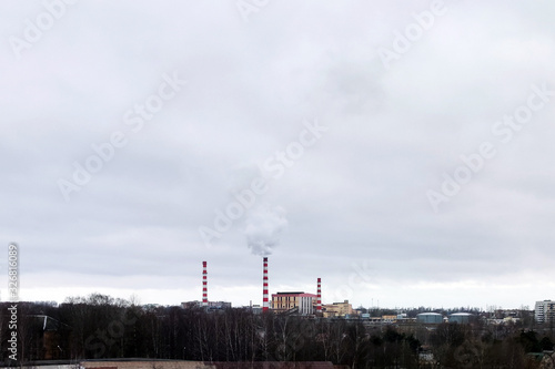 Old thermal station on the outskirts of city. With smoke from pipes