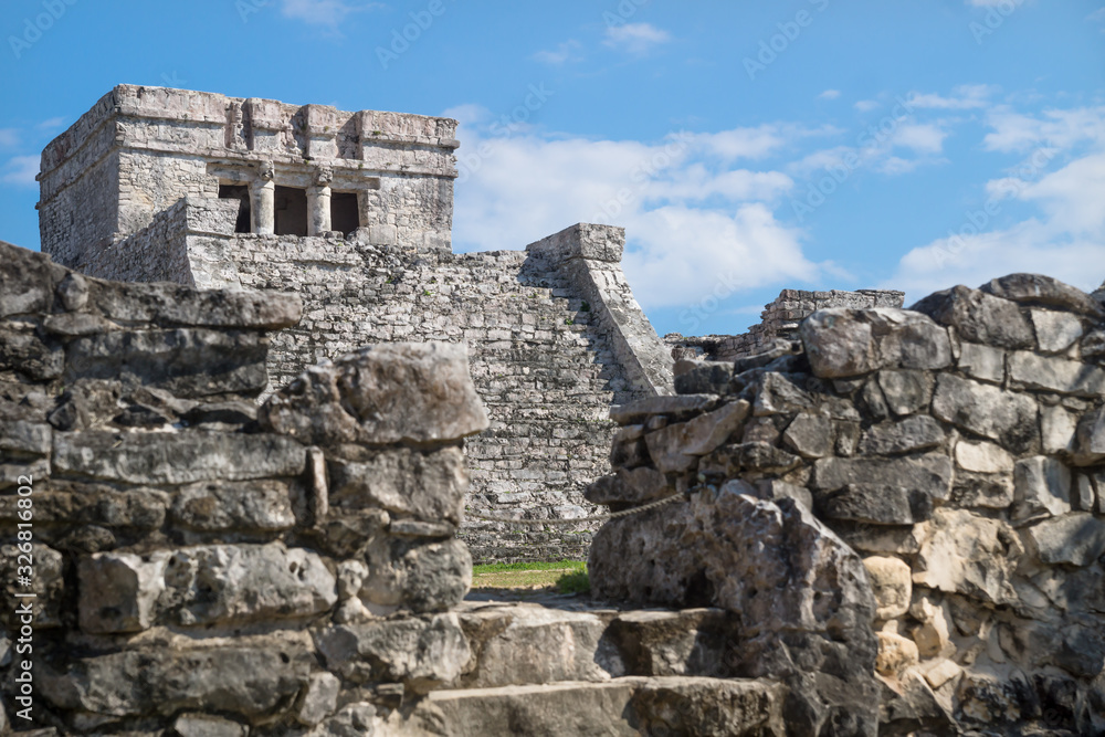 El Castillo Maya ruins behind blurred wall, Tulum, Mexico