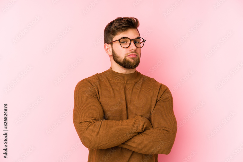 Obraz premium Young caucasian man isolated on pink background suspicious, uncertain, examining you.