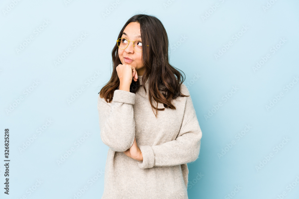 Young mixed race hispanic woman isolated relaxed thinking about something looking at a copy space. Young mixed race hispanic woman isolated relaxed thinking about something looking at a copy space.