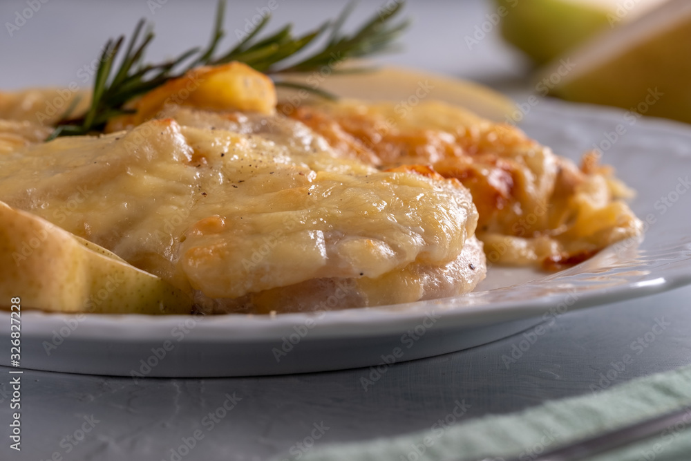 Fresh and juicy chicken breast stuffed with pear and cheese with crispy crust on a white plate Fresh and juicy chicken breast stuffed with pear and cheese with crispy crust on a white plate