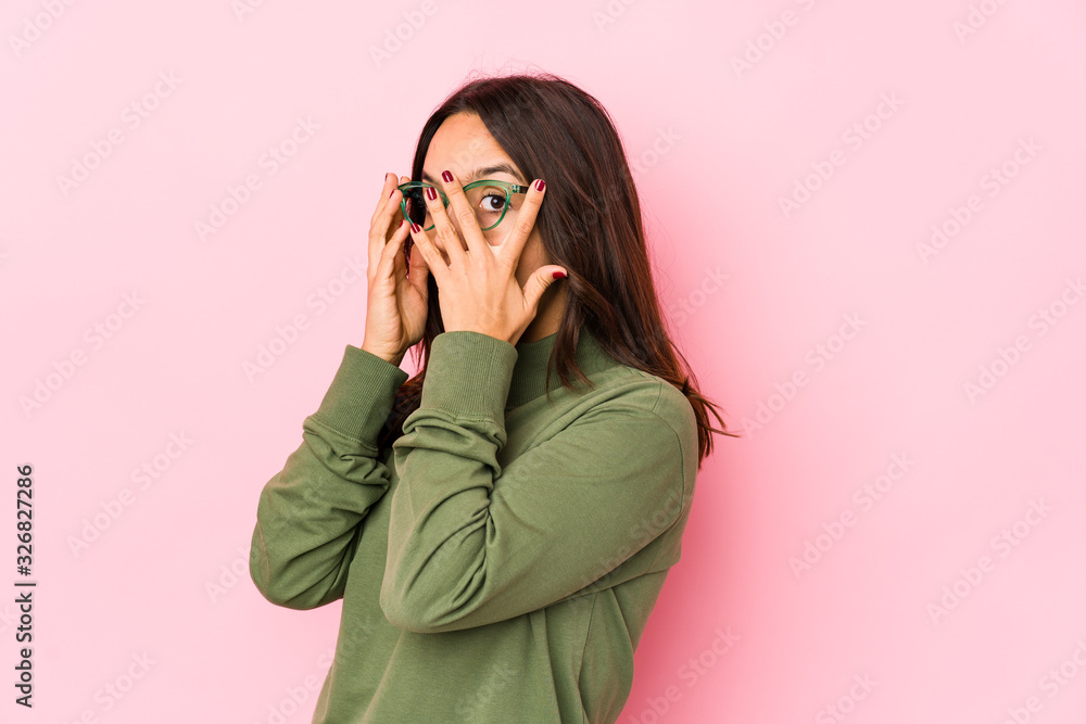 Young mixed race hispanic woman isolated blink through fingers frightened and nervous. Young mixed race hispanic woman isolated blink through fingers frightened and nervous.