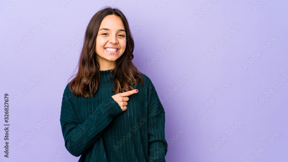 Young mixed race hispanic woman isolated smiling and pointing aside, showing something at blank space.