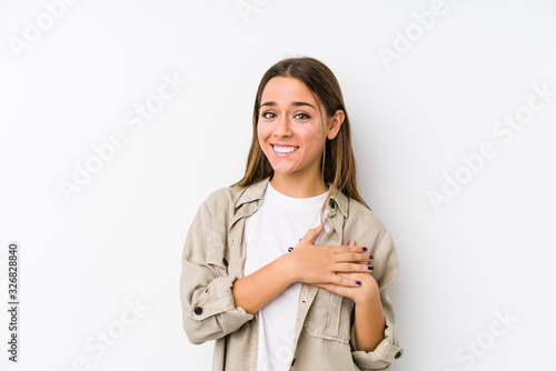 Young caucasian woman  isolated has friendly expression, pressing palm to chest. Love concept.