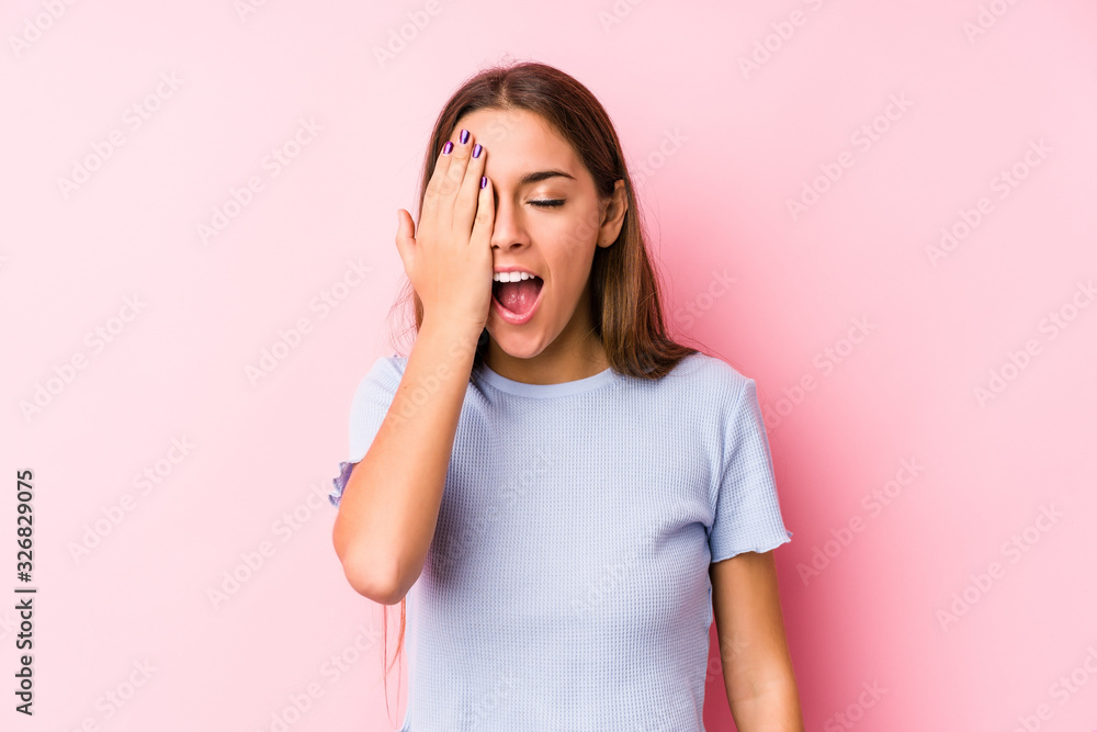 Young caucasian woman wearing a ski clothes isolated having fun covering half of face with palm. Young caucasian woman wearing a ski clothes isolated having fun covering half of face with palm.