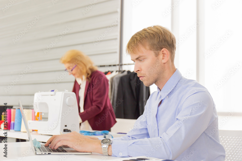 Obraz premium Professional team work designers, young men and elderly women in the office with a variety of fabric tones and equipment for various designs.