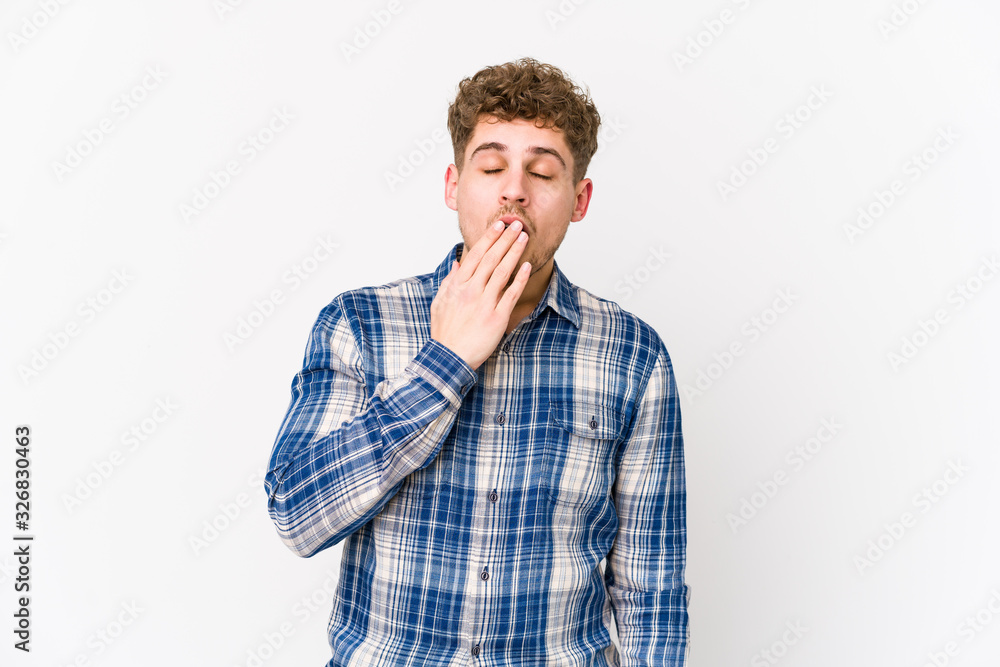 Young blond curly hair caucasian man isolated yawning showing a tired gesture covering mouth with hand. Young blond curly hair caucasian man isolated yawning showing a tired gesture covering mouth with hand.