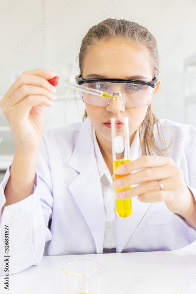 A beautiful female scientist is operating in a science lab with various equipment in the lab. A beautiful female scientist is operating in a science lab with various equipment in the lab.