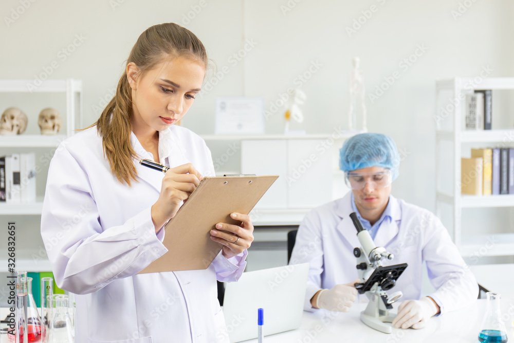 Scientists, young men and women in the laboratory and have a beautiful orange light. Scientists, young men and women in the laboratory and have a beautiful orange light.