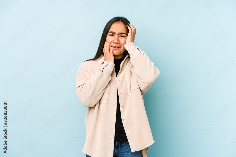 Young woman isolated on a blue background whining and crying disconsolately. Young woman isolated on a blue background whining and crying disconsolately.