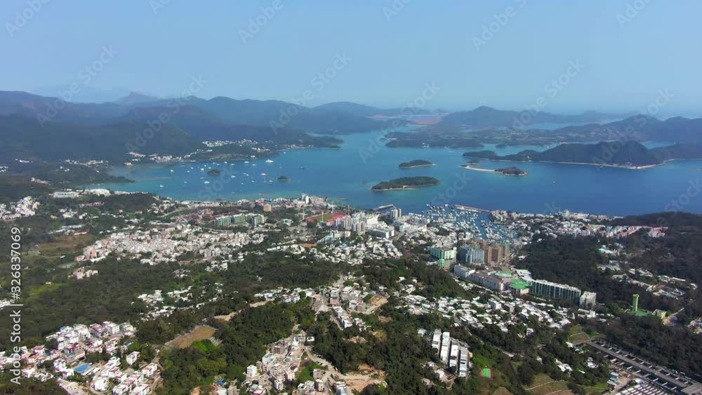 Aerial view of Hong Kong Sai Kung district with rooftops, marina and small islands in the horizon on a beautiful clear day. Aerial view of Hong Kong Sai Kung district with rooftops, marina and small islands in the horizon on a beautiful clear day.