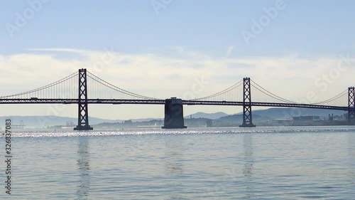 dolly shot pulling back from the bay bridge showing the bay area on a winter's sunny day. water glistening in the sun photo