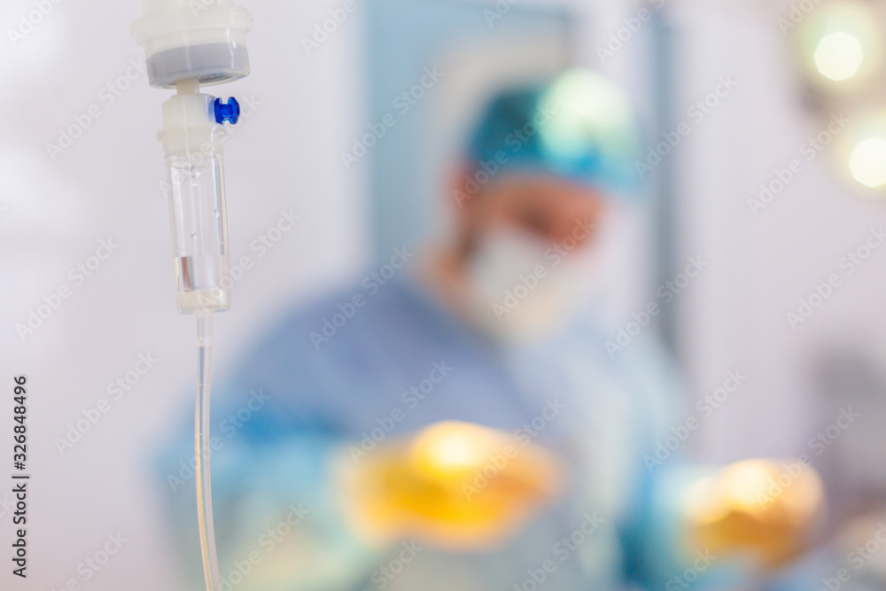 Hospital. Surgeon operates in the operating room. Dropper on a blurry background with operating doctors Hospital. Surgeon operates in the operating room. Dropper on a blurry background with operating doctors