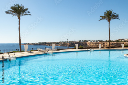 Beautiful pool overlooking the sea  on a background of blue sky  water. Luxurious tropical beach. Seascape The concept of rest.