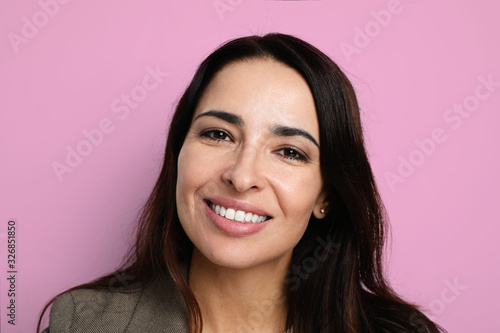 Portrait of young and beautiful woman smiling and posing on the pink background. Isolated.