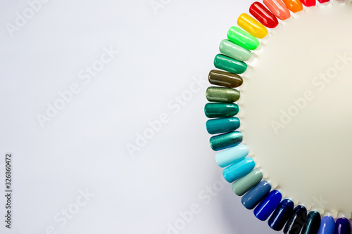 Palette with color samples of nail polish isolated on white background. different bright colors.advertising for Colorful nail lacquer manicure swatches. Top view of nail art wheel palette. Copy space