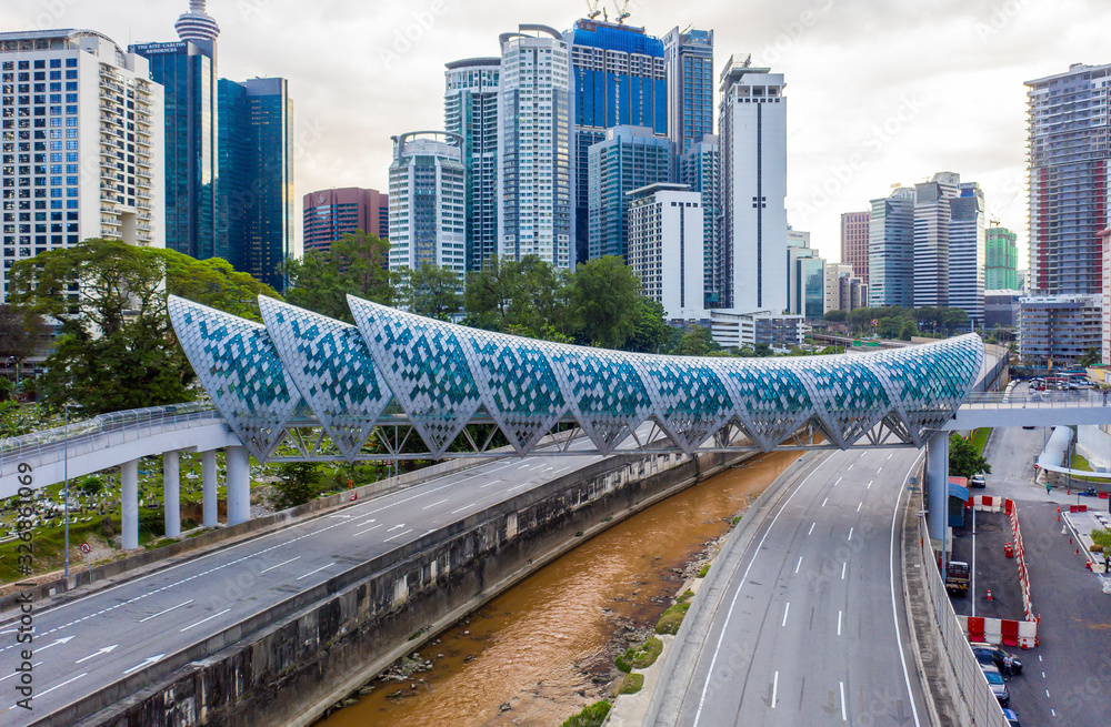 Naklejka premium Kuala Lumpur, Malaysia - February 22, 2020 : Aerial drone view of newly opened pedestrian bridge Saloma Link connecting Kampung Baru with Ampang road.