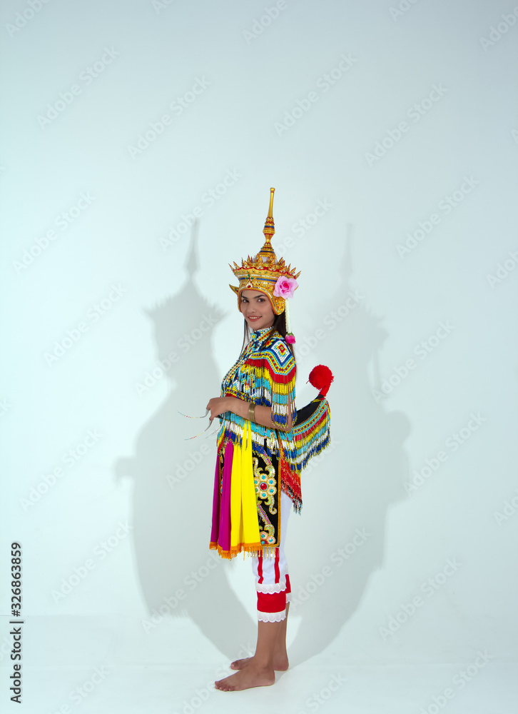 The beautiful woman wearing Thai Tradition southern costume and put headdress on her head,standing on white background,folk dance,black shadow reflection on white background