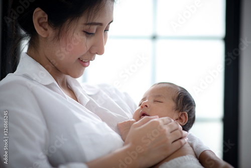 Asian parent hands holding newborn baby fingers, Close up mother's hand holding their new born baby. Love family healthcare and medical