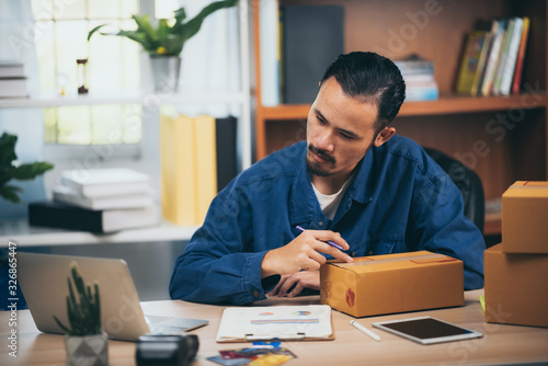 Young man entrepreneur selling online product sitting smile happily in him workplace. photo