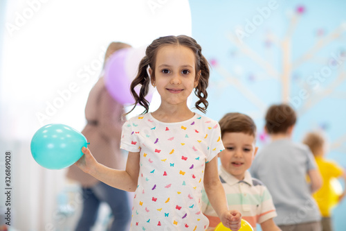 Kid girl with balloon on pa...