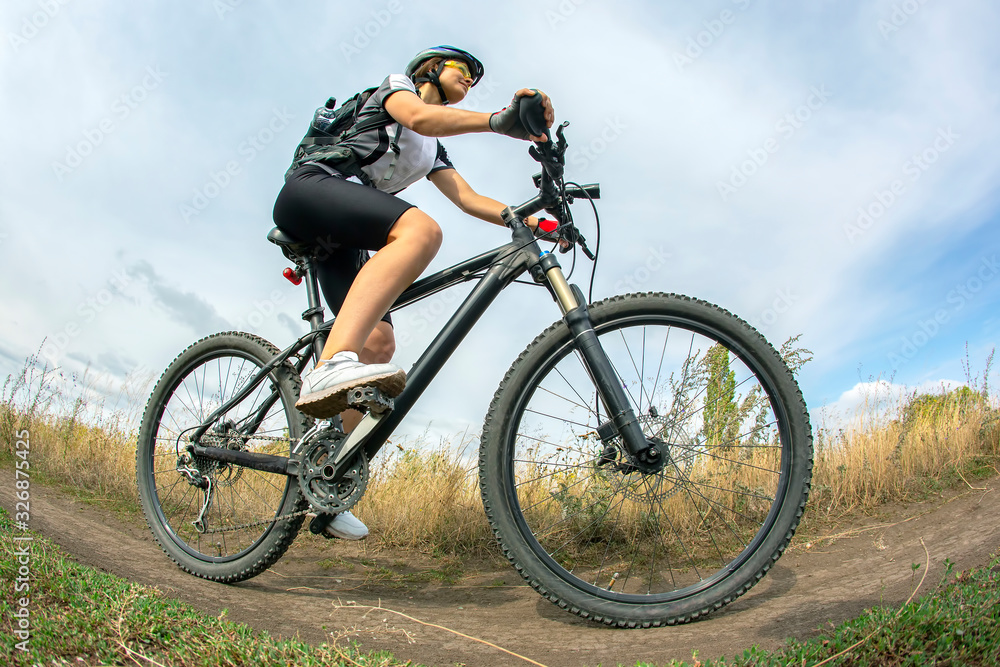 Beautiful girl cyclist with a bicycle on the nature. Healthy lifestyle and sport. Leisure and hobbies Beautiful girl cyclist with a bicycle on the nature. Healthy lifestyle and sport. Leisure and hobbies