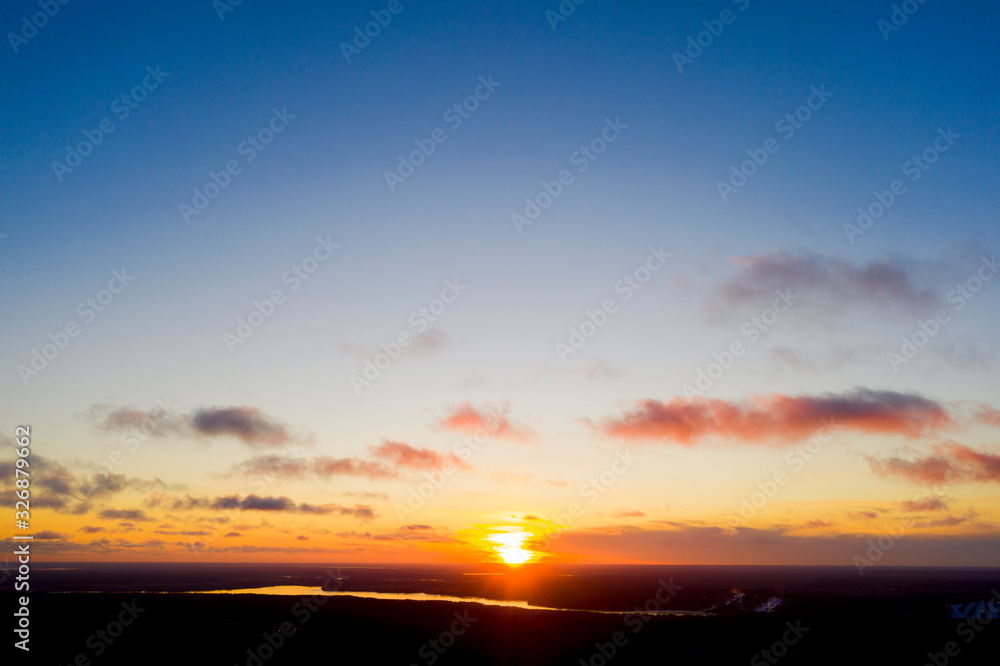 Aerial view sunset over the forest and lake. Top view. View from drone. Aerial top view cloudscape. Texture of clouds. View from above. Sunrise or sunset over clouds