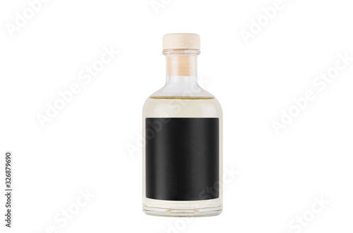 Transparent glass bottle for cosmetic, perfume, alcohol drink with black label, cork, yellow liquid isolated on white background, mock up for design.