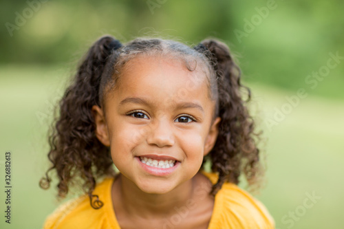 Cute mixed race little girl laughing and smiling.