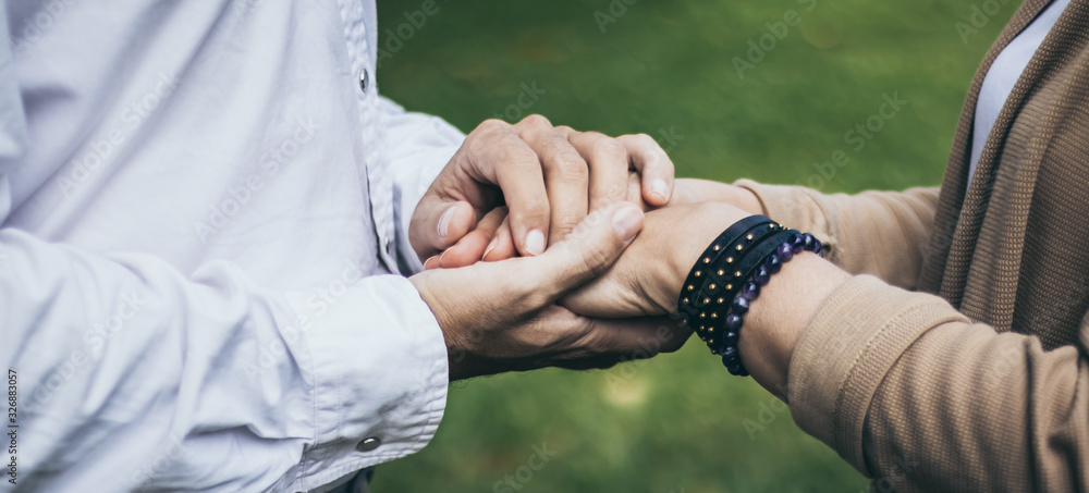 Lovely senior elderly smiling couple man and woman holding hand as promising of forever love or take care in romantic moment. Warm heart marriage and lover bonding and relationship. Love photo concept