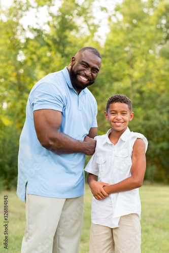 Father and his son laughing and playing at the park.