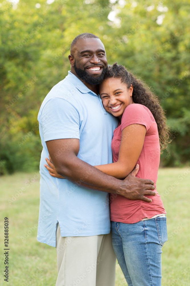 Father and his daughter laughing and playing at the park.