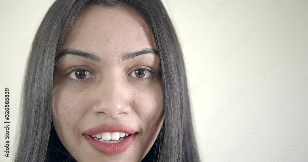 Close-up of Indian woman wearing red smiling and happy with joyous and joy as she looks and smiles with toothy smile is generally in a positive content state on her face Close-up of Indian woman wearing red smiling and happy with joyous and joy as she looks and smiles with toothy smile is generally in a positive content state on her face