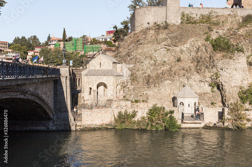 The Metekhi St. Virgin Church stands on the banks of the Mtkvari river in Tbilisi city in Georgia photo