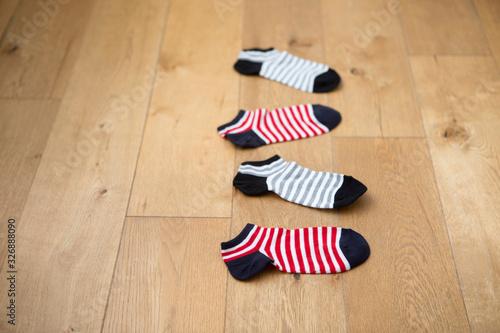 red and gray striped socks on hardwood floor