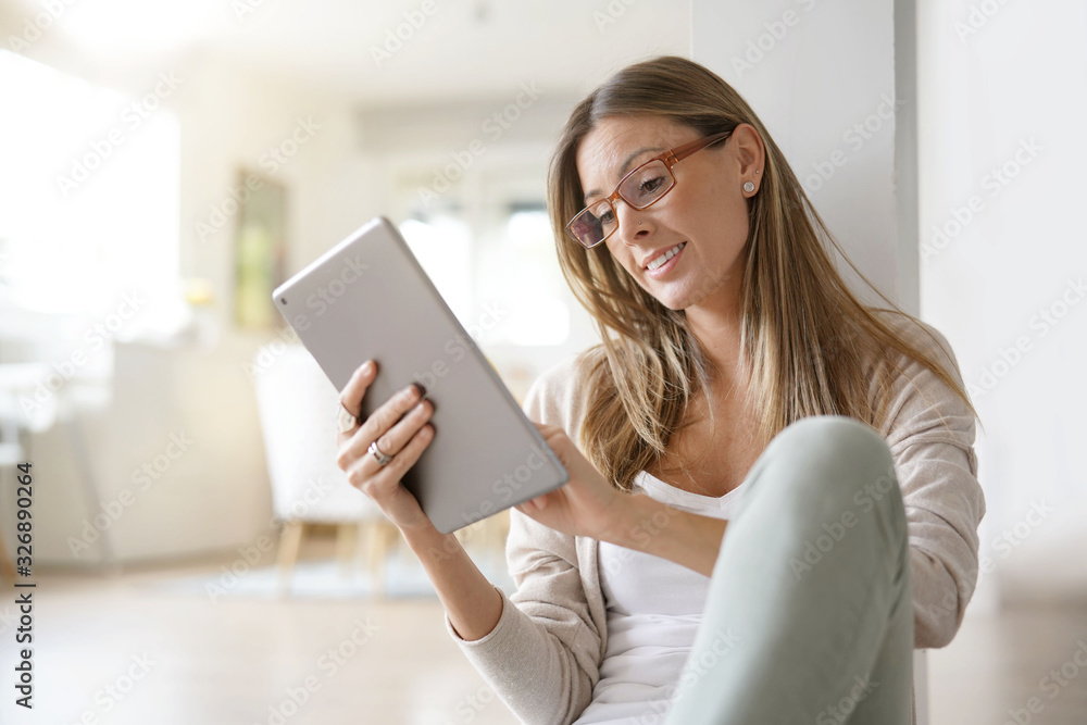 Woman at home relaxing and websurfing with digital tablet Woman at home relaxing and websurfing with digital tablet