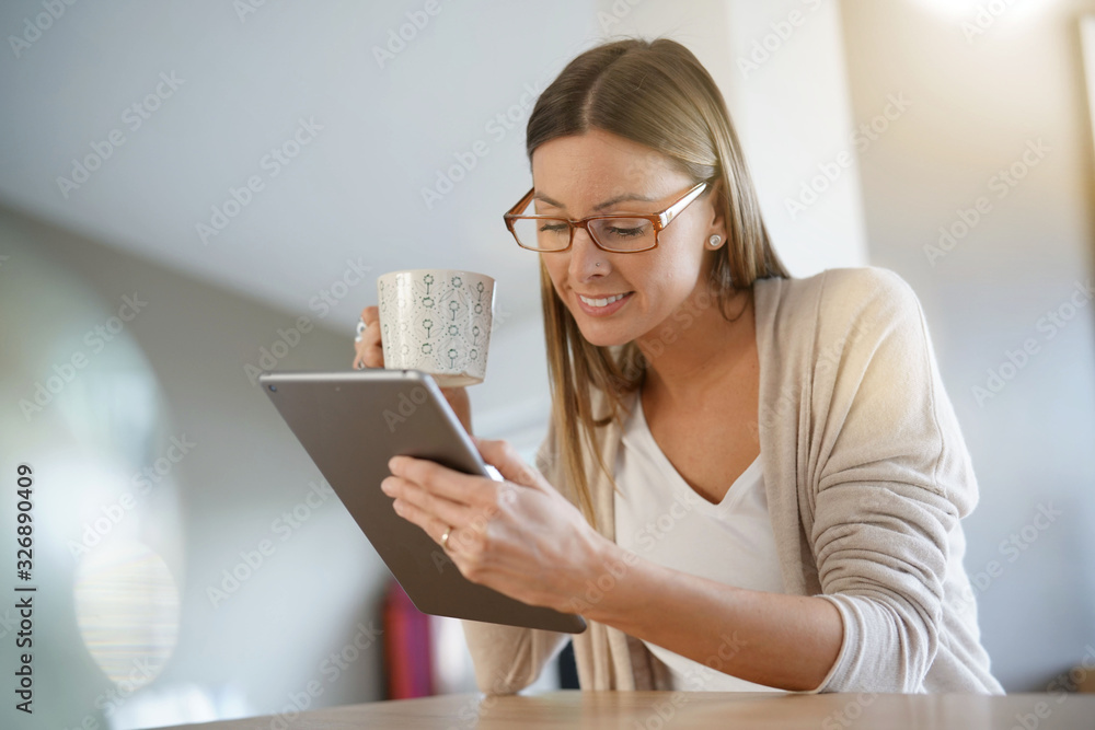 Portrait of woman with eyeglasses connected with tablet