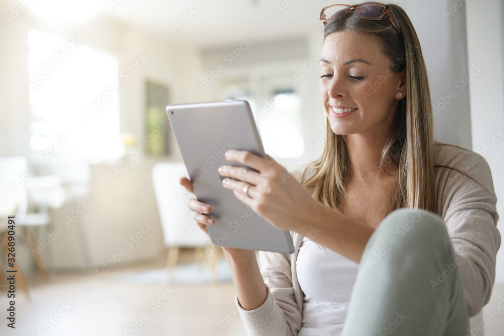 Woman at home relaxing and websurfing with digital tablet Woman at home relaxing and websurfing with digital tablet