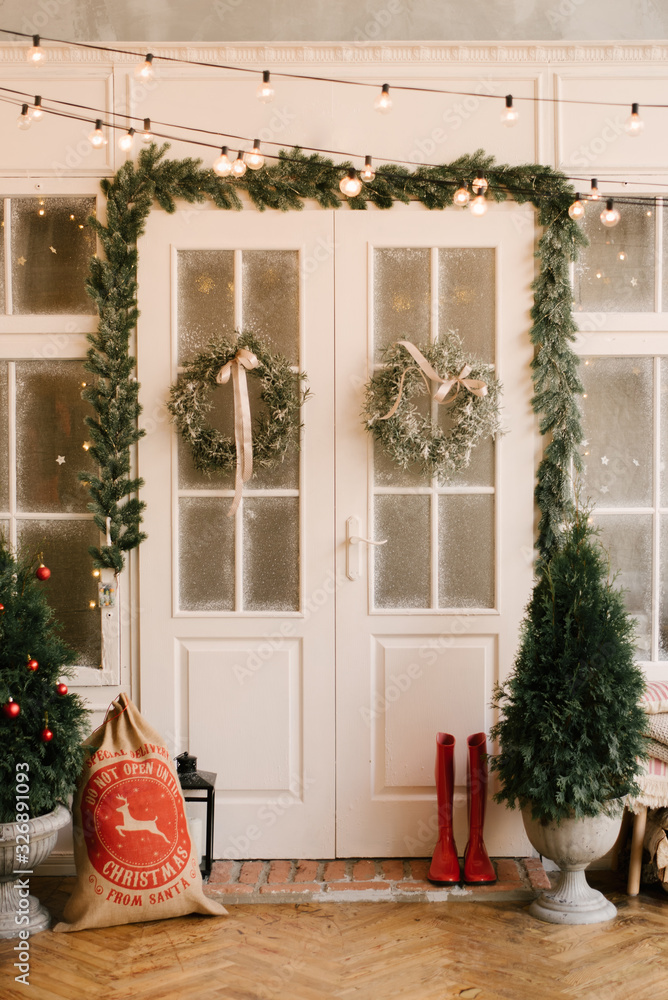 The decor of Christmas and New year. Beautiful facade decorated with wreaths of spruce, selective focus The decor of Christmas and New year. Beautiful facade decorated with wreaths of spruce, selective focus