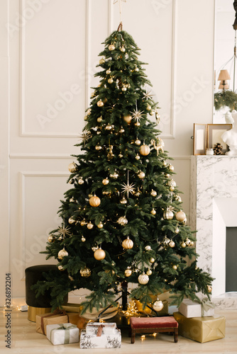 The decor of Christmas and New year. Christmas tree with toys and gifts