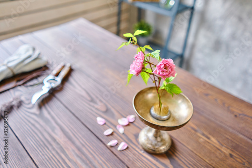 Ikebana in kenzan, scissors and pruner on the table florist. Seasonal summer garden flowers.