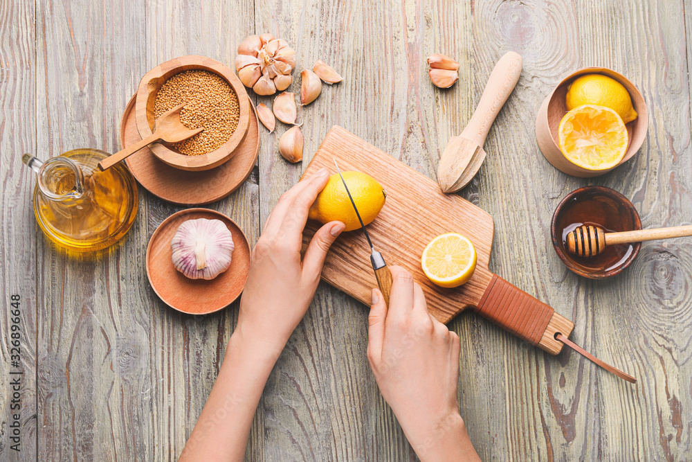 Woman preparing tasty honey mustard sauce on wooden table Woman preparing tasty honey mustard sauce on wooden table