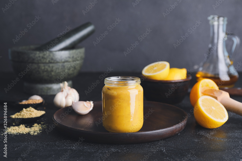 Jar of tasty honey mustard sauce on dark background Jar of tasty honey mustard sauce on dark background